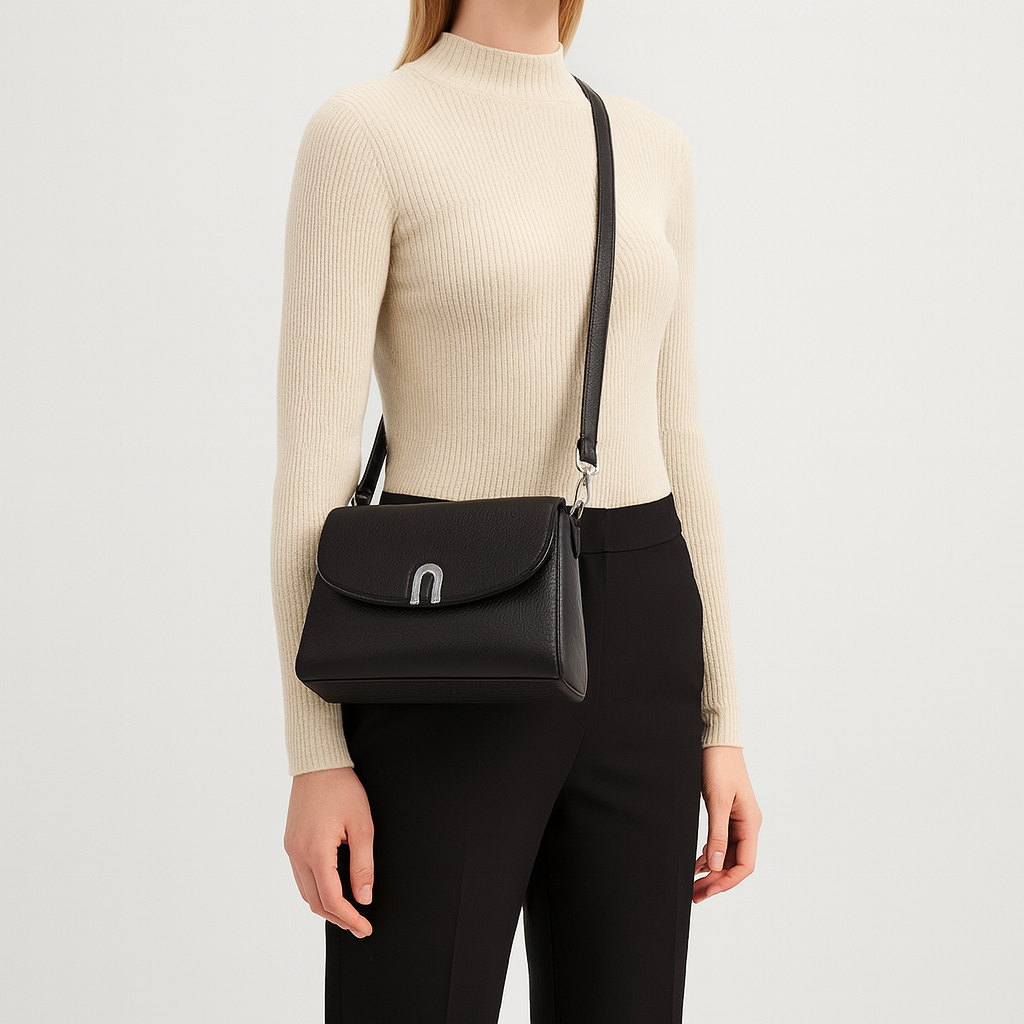 Structured crossbody bag with curved flap and metal clasp.