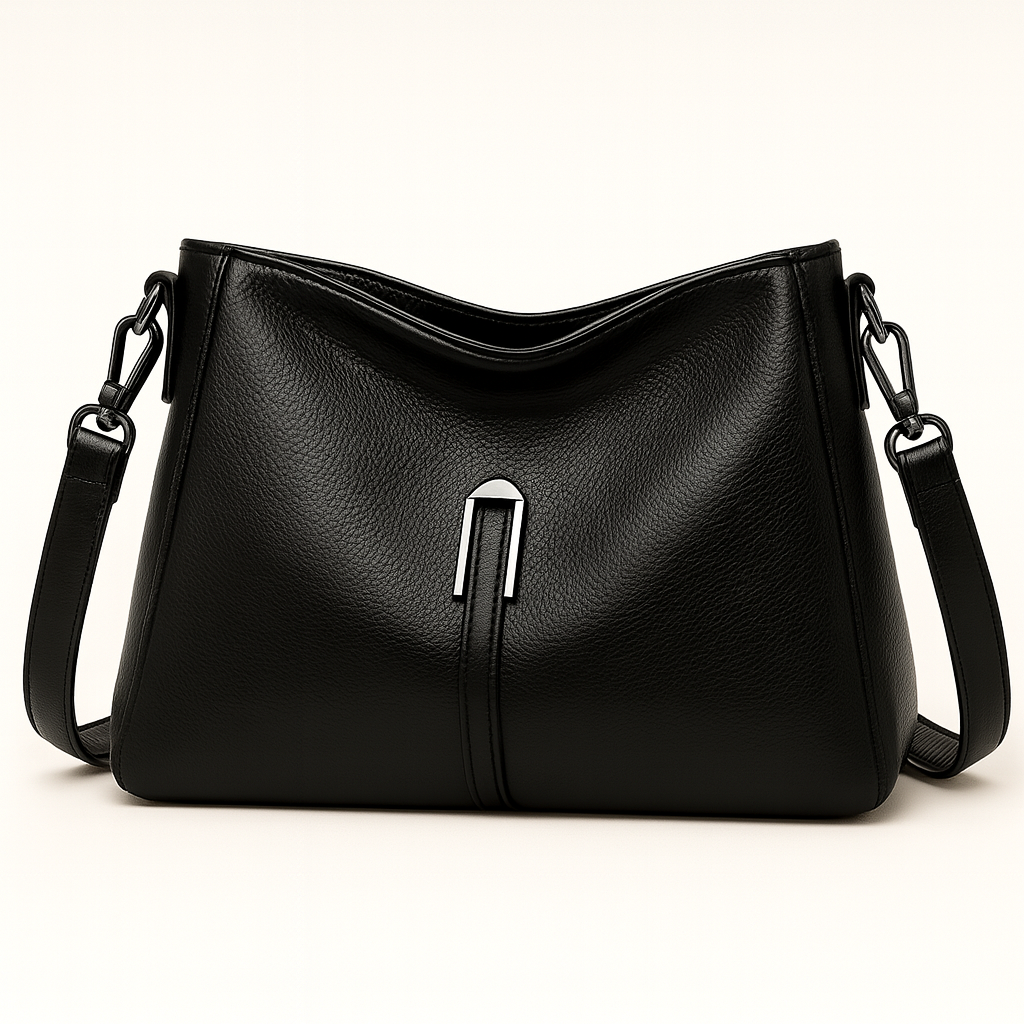 Soft-structured shoulder bag with single metal accent and adjustable strap.