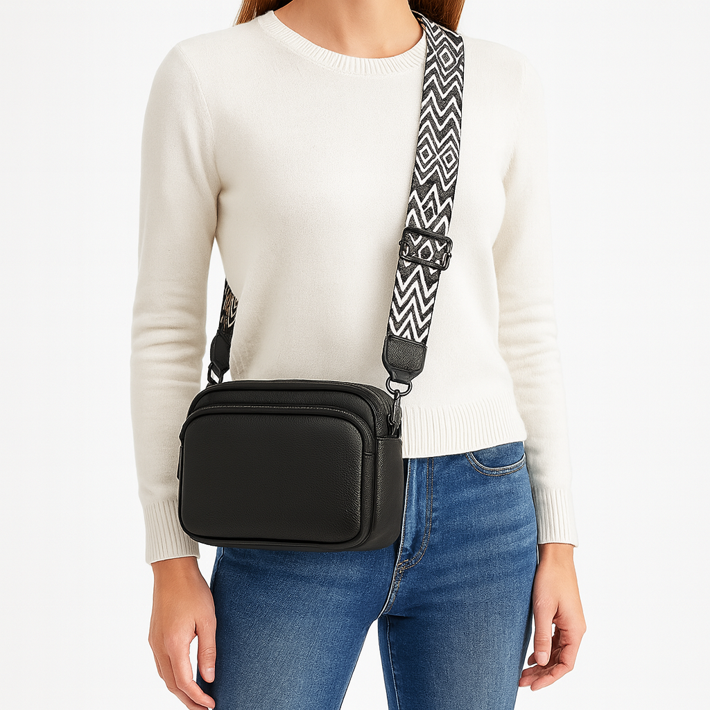 Crossbody bag with zip pocket and patterned strap.